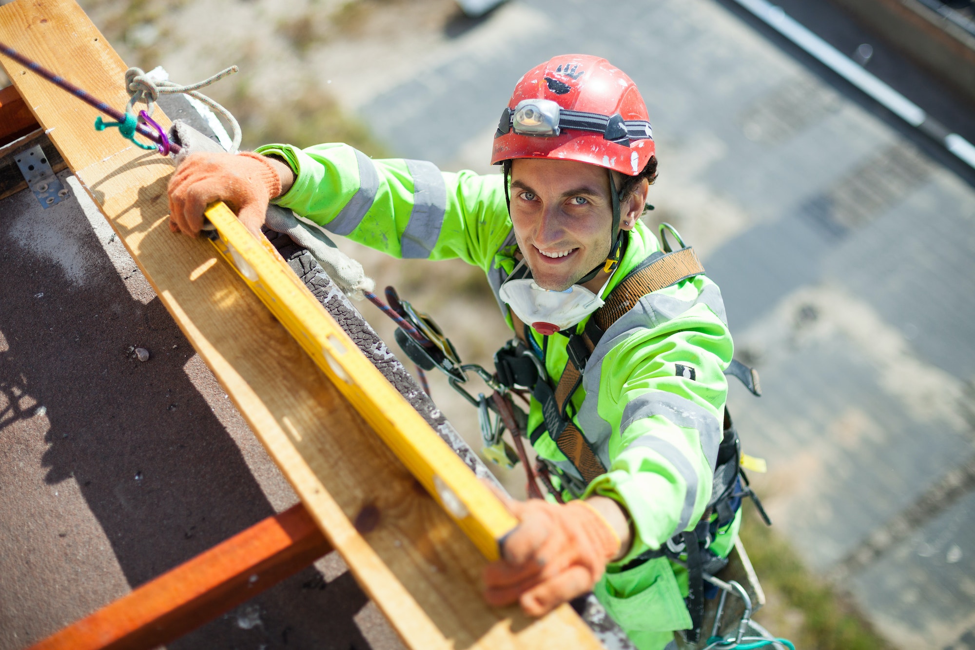 Industrial climber measuring with level tube during construction works